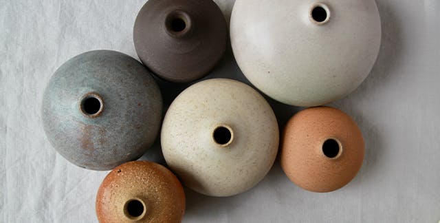 Close-up of an array of different coloured ceramic vases.